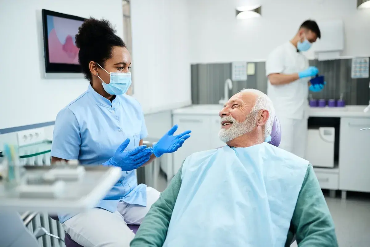 A dental clinician preparing to treat an older patient in a modern clinic