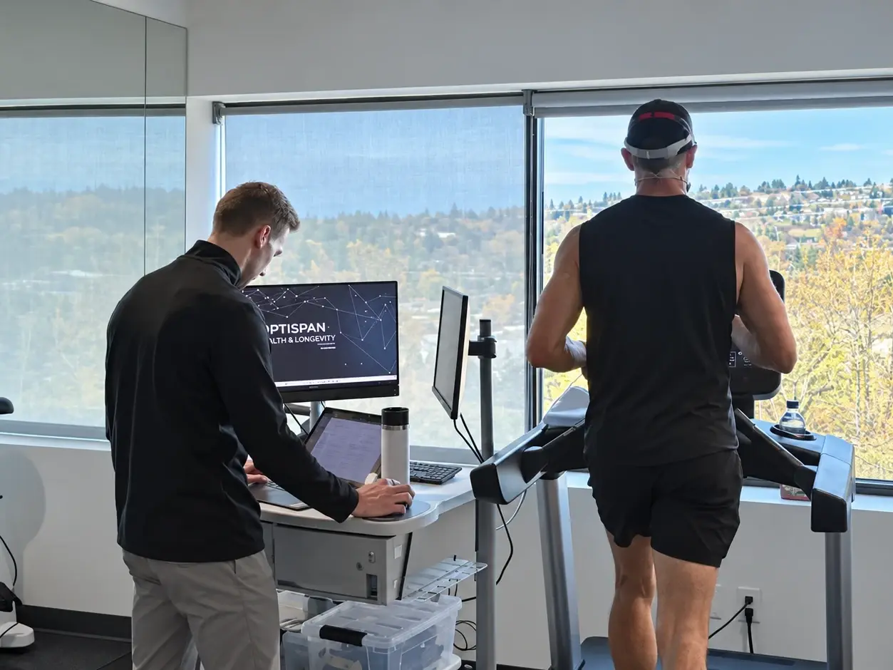 A VO₂ max test underway at the Optispan clinic, with a client on the treadmill and a coach at the monitor.