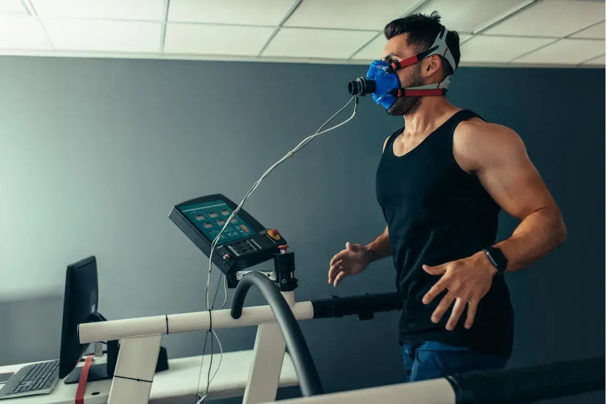 A man running on a treadmill in a metabolic mask during a VO₂ max test